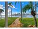 Lush backyard with stone pathway leading to a private dock and stunning waterfront views at 11683 Grove St, Seminole, FL 33772