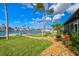 Backyard featuring lush landscaping, stone pathway, and waterfront access with a private dock at 11683 Grove St, Seminole, FL 33772