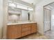 Bathroom vanity with double sinks, stylish fixtures, and a large mirror with vanity lighting at 11683 Grove St, Seminole, FL 33772