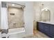 Bathroom features tiled shower and bath alongside double sink vanity with marble countertop and arch mirror at 11683 Grove St, Seminole, FL 33772