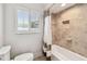 Bright bathroom featuring a tiled shower over tub and white shutters at 11683 Grove St, Seminole, FL 33772