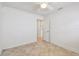 This bedroom features neutral walls, tile floors, a ceiling fan, and an entry door at 11683 Grove St, Seminole, FL 33772