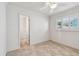 Bright bedroom with tiled floor, white walls, ceiling fan and a window with plantation shutters at 11683 Grove St, Seminole, FL 33772