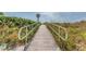 Boardwalk with railings offers a scenic stroll through lush beach vegetation at 11683 Grove St, Seminole, FL 33772