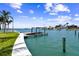 Beautiful waterfront home with lush lawn leading to dock and boat lift on the canal at 11683 Grove St, Seminole, FL 33772