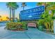 Welcoming entrance to John's Pass Village & Boardwalk with lush landscaping and a charming bench at 11683 Grove St, Seminole, FL 33772
