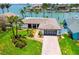 Inviting waterfront home featuring lush landscaping, a modern garage door, and serene water views at 11683 Grove St, Seminole, FL 33772