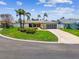 Charming single-story home with a modern garage door, a well-manicured lawn, and a curved driveway at 11683 Grove St, Seminole, FL 33772