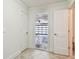 Hallway with neutral walls, tile flooring, and multiple doors including an open door to a garage at 11683 Grove St, Seminole, FL 33772