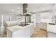 Large kitchen island with quartz countertop and modern vent hood over cooktop at 11683 Grove St, Seminole, FL 33772