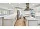 Spacious kitchen with white cabinetry, stainless appliances, and large breakfast bar at 11683 Grove St, Seminole, FL 33772