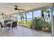 This lanai features a screened in enclosure, tile floor, ceiling fans, dining set, and waterfront views at 11683 Grove St, Seminole, FL 33772