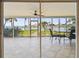 Screened lanai with tile flooring, a ceiling fan, and views of the landscaped backyard and waterfront at 11683 Grove St, Seminole, FL 33772