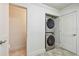 This laundry room features a modern stackable washer and dryer and a door to another room at 11683 Grove St, Seminole, FL 33772