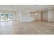 Spacious living room featuring neutral tile flooring, a breakfast bar, and a sliding glass door to a waterfront view at 11683 Grove St, Seminole, FL 33772