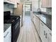 Galley kitchen with granite countertops and wood-look tile floor at 1960 Union St # 25, Clearwater, FL 33763