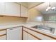 Kitchen with white cabinets, dishwasher and a breakfast bar at 2333 Feather Sound Dr # B101, Clearwater, FL 33762