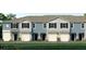 Three-unit townhome building, light blue exterior, white garage doors, and landscaping at 2472 Mellow Ln, Clearwater, FL 33765