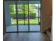 View from the interior through sliding glass doors of the back patio and green backyard at 2472 Mellow Ln, Clearwater, FL 33765