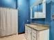 Bathroom with blue walls, white vanity, granite countertop, and shower at 364 Terrace Rd, Tarpon Springs, FL 34689