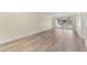 Bright living room with wood-look floors and sliding glass doors leading to a screened porch at 4220 Sheldon Pl # 4220, New Port Richey, FL 34652