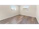 Simple bedroom with wood-look floors and two windows at 4220 Sheldon Pl # 4220, New Port Richey, FL 34652