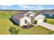 Tan one-story house with a two-car garage, and manicured lawn at 6731 Wirevine Dr, Brooksville, FL 34602