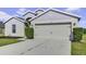 Two-car garage and neutral color exterior with landscaping at 6731 Wirevine Dr, Brooksville, FL 34602