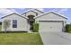 Single-story home with neutral exterior, two-car garage, and well-manicured lawn at 6731 Wirevine Dr, Brooksville, FL 34602