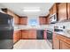 Modern kitchen with wood cabinets, granite countertops, and stainless steel appliances at 6731 Wirevine Dr, Brooksville, FL 34602
