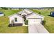 One-story home with tan exterior, two-car garage, and landscaping at 6731 Wirevine Dr, Brooksville, FL 34602