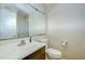 Bathroom featuring a large mirror, vanity, and toilet with mounted toilet paper holder at 10100 Sailwinds N Blvd # 106, Largo, FL 33773