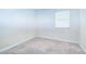 Bedroom featuring neutral carpet, ample lighting, and a large window at 10100 Sailwinds N Blvd # 106, Largo, FL 33773