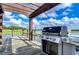 Dockside outdoor kitchen featuring a stainless steel grill and scenic water views at 10100 Sailwinds N Blvd # 106, Largo, FL 33773