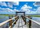 Wooden dock featuring a seating area, grill, and lovely lake views at 10100 Sailwinds N Blvd # 106, Largo, FL 33773