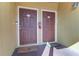 Dual unit front doors with a welcome mat, fire extinguisher, and unit numbers, creating a charming entrance at 10100 Sailwinds N Blvd # 106, Largo, FL 33773