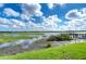 Scenic lake view featuring a wooden dock, lush greenery, and serene water reflecting the sky at 10100 Sailwinds N Blvd # 106, Largo, FL 33773