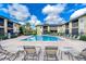 Community swimming pool with lounge seating and well-maintained landscaping for a relaxing atmosphere at 10100 Sailwinds N Blvd # 106, Largo, FL 33773