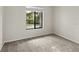 Bright bedroom with neutral carpeting and a window at 1127 Pine Ridge W Cir # A2, Tarpon Springs, FL 34688