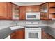 Kitchen with wood cabinets, white appliances, and corner sink at 1127 Pine Ridge W Cir # A2, Tarpon Springs, FL 34688