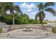 Large backyard with stone pavers, sitting area, lush greenery, and lake view at 12013 Whistling Wind Dr, Riverview, FL 33579