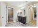 Well-lit bathroom with tile flooring, dark vanity, large mirror, and neutral paint at 12013 Whistling Wind Dr, Riverview, FL 33579