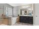 Bathroom showcasing a tub, shower with tile accents, dark vanity, and large mirror at 12013 Whistling Wind Dr, Riverview, FL 33579