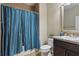 Neutral bathroom featuring a shower with a blue curtain, and a vanity with a white sink at 12013 Whistling Wind Dr, Riverview, FL 33579