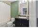 Bathroom featuring a dark vanity, with a toilet and shower with green walls at 12013 Whistling Wind Dr, Riverview, FL 33579