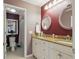 Bathroom with a double vanity, granite countertop, decorative mirrors, and a separate toilet area at 12013 Whistling Wind Dr, Riverview, FL 33579