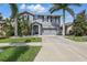 Two-story home with gray exterior, well-maintained lawn, tropical landscaping, and an attached two-car garage at 12013 Whistling Wind Dr, Riverview, FL 33579