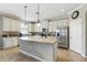 Bright kitchen with stainless steel appliances, granite countertops, white cabinets, and large center island at 12013 Whistling Wind Dr, Riverview, FL 33579