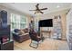 Spacious living room with ceiling fan, large window, gaming set up, and display shelving for shoes at 12013 Whistling Wind Dr, Riverview, FL 33579