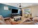Living room featuring blue accent wall, tile flooring, entertainment center, brown sofa, and modern furniture at 12013 Whistling Wind Dr, Riverview, FL 33579